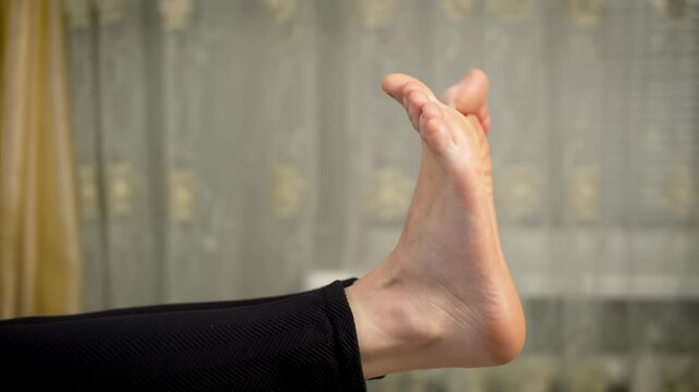 Barefoot woman moving her toes. Female without shoes wiggles toes. Barefoot lady gently moves toes