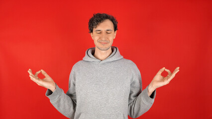 Calm relaxed man meditating closed eyes hands spread practices yoga breathes deeply. isolated on...