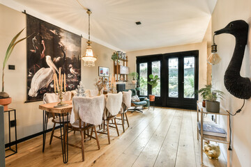 A beautifully designed dining room featuring a mix of modern and natural elements, abundant greenery, and artistic wall decor for an inviting atmosphere.