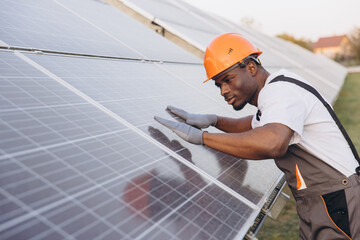 African American Male Engineer Inspecting Solar Panels for Efficient Energy Production