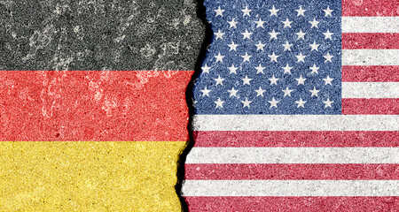 German American tension and conflict. A geopolitical crack, split shows US and Germany flags on...