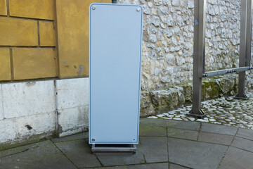 Blank advertising board stand placed at an urban street corner. The simple and clean design creates...