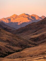 Majestic sunset illuminating a breathtaking mountain range. Golden hour casts warm hues across rugged peaks and valleys.