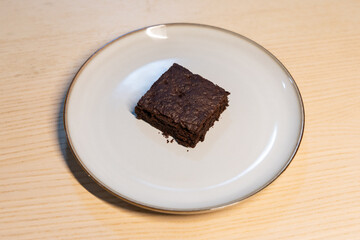 A piece of brownie on the plate.