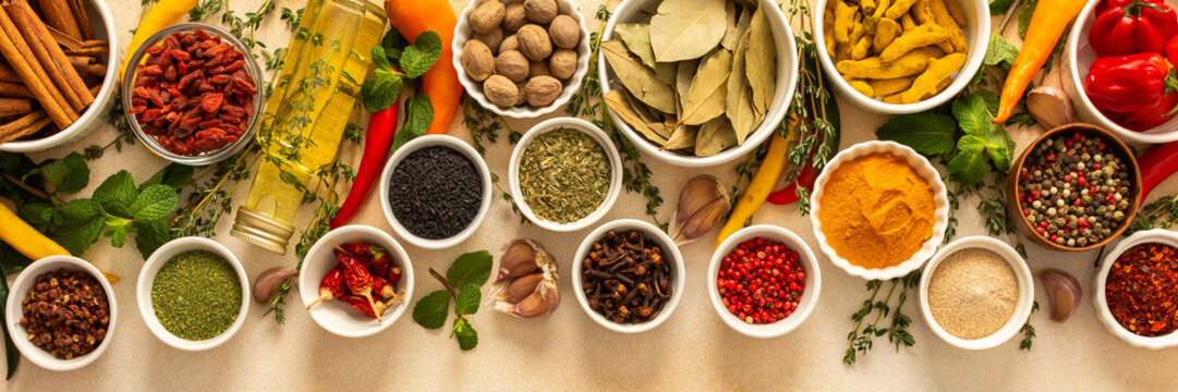 Variety of vibrant spices and dried herbs arranged on a beige backdrop, essential for culinary seasoning and enriching dishes with aromatic, natural flavors, banner - Powered by Adobe