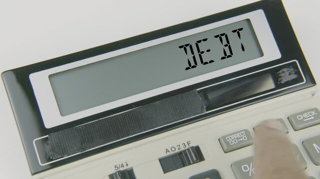 "Debt" text or words displayed on a calculator's LED screen as a hand types numbers, symbolizing the calculation or management of money owed or financial obligations
