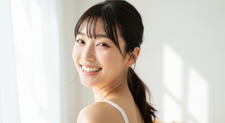Smiling Asian woman looking over her shoulder in a health and beauty context