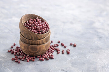 Bowls full of dried red azuki beans on gray closeup. East Asian legumes, vegetarian protein source
