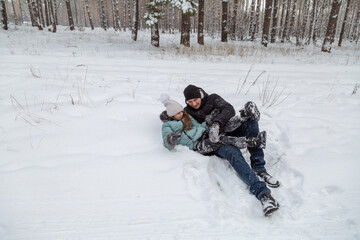 Dad and daughter walking and having fun in snowy winter forest