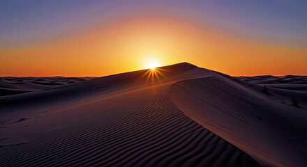 Peaceful desert dusk captures sun disappearing behind rolling smooth sand dune formation in tranquil setting