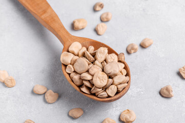 Organic raw dry Grass pea close up on wooden spoon. Healthy, protein source for vegan and vegetarian diet. Traditional Italian apulian cuisine ingredient. Legumes known as Cicerchia, Vetch, Indian Pea