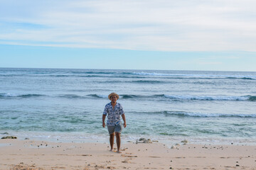 A happy southeast asian traveller at the beach