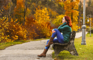 Woman sitting on a bench in autumn scenery in Fussen, Germany