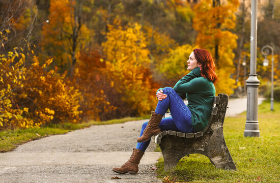 Woman sitting on a bench in autumn scenery in Fussen, Germany