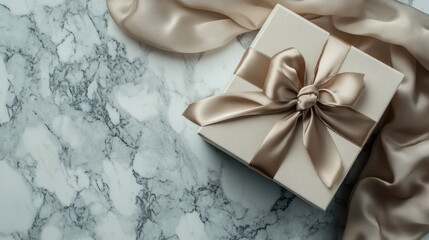 Elegant gift box with silk ribbon on marble surface, top down