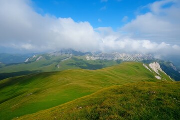 Fototapeta premium Lush green hills under cloudy blue sky, mountainous backdrop visible