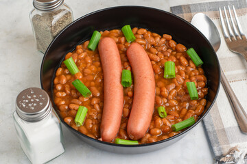 hot dogs  on baked beans top with green onions