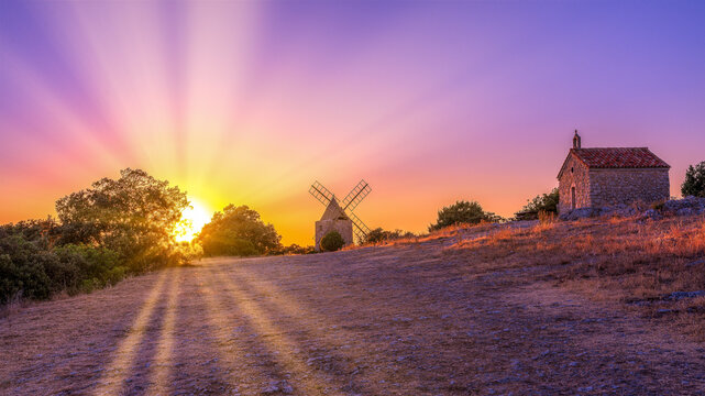 Un moulin et une chapelle dans le coucher de soleil dans le Luberon, région du Sud de la France