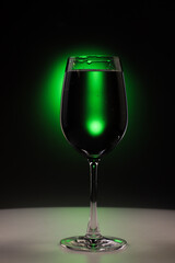 glass of wine. Drink water for health concept. Clean water as clear as crystal glass on black background with green light.