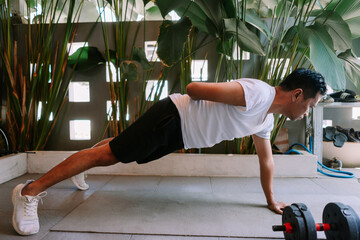 Asian man performing push-ups exercise at home for fitness routine
