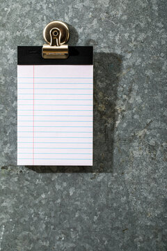 Blank white lined pad of paper on magnet board