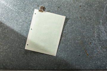 Blank pale green graph paper angled on magnet board