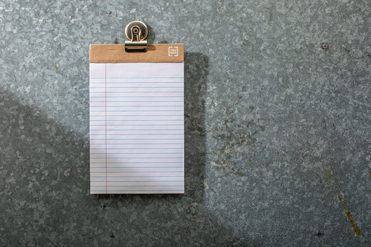 Blank white lined pad of paper on magnet board