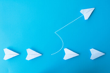 Top view of white paper airplanes origami with one flying at different direction