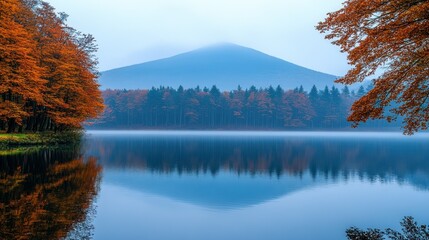 Fototapeta premium Autumn lake mirroring mountain in mist