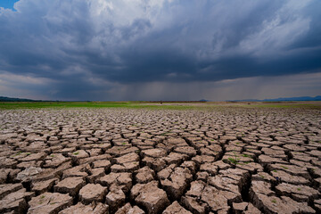 The parched ground is cracked and the storm is coming.