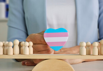 Balancing support for the transgender community with wooden figures in a symbolic representation of...