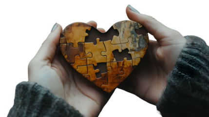 Conceptual image of holding a broken heart-shaped puzzle piece symbolizing love and relationships
