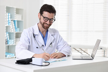 Professional doctor working at white desk in hospital