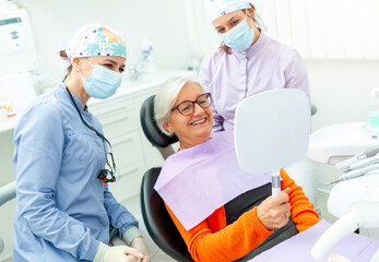 Senior woman admiring her smile after dental checkup