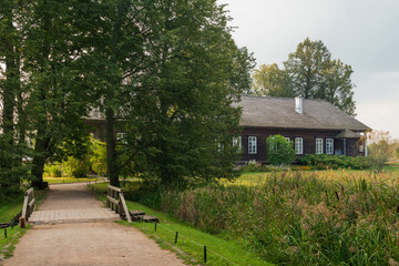 View of the Osipov-Wolf House Museum on the bank of the Factory Pond in the Trigorskoye Estate of Pushkin Natural Landscape Reserve on a sunny summer day, Pushkinskiye Gory, Pskov Region, Russia