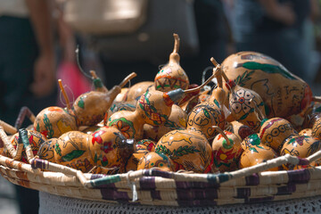 Traditional hand-painted Cypriot gourds nestled in woven basket, highlighting artisan craftsmanship and history
