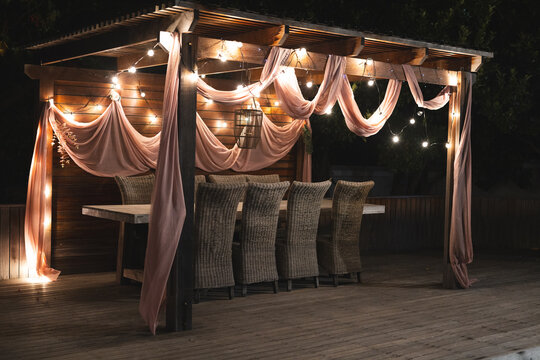 Outdoor dining area beautifully decorated with draped fabric and string lights