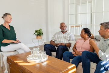 African American family having heartfelt conversation with therapist in living room