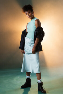 Confident woman in stylish outfit posing in edgy studio lighting