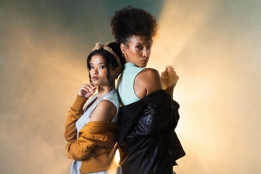 Confident women posing back-to-back in stylish grunge fashion, exuding attitude