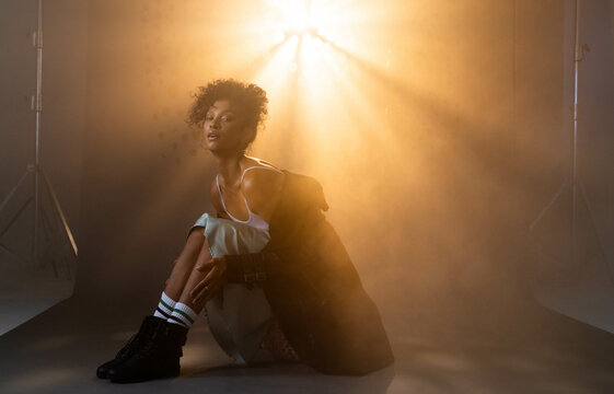 Model posing confidently in dramatic lighting, wearing stylish grunge fashion