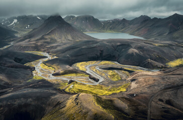 Aerial view of colorful volcanic dramatic landscape in Landmannalaugar during cloudy summer day with picturesque volcanic cones, glacial river and lake. Iceland 