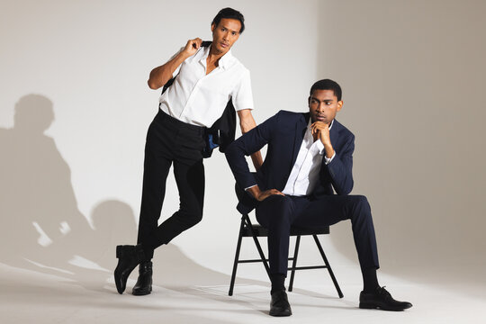 Confident men in stylish suits posing in modern fashion studio