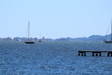 Boats anchored on a quiet beach with docks on a sunny day