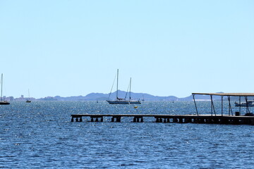 Boats anchored on a quiet beach with docks on a sunny day