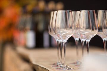 Empty wine glasses on a stock background with bottles