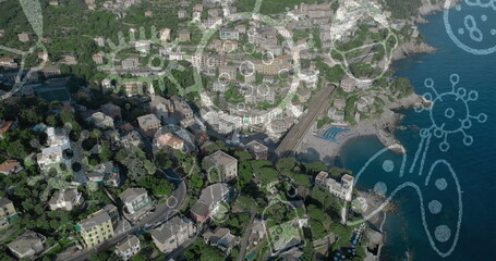 Image of Covid 19 icons flowing over aerial view of cityscape