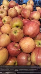 Fresh red and yellow apples piled in a display crate at a grocery store. The image reflects themes of healthy lifestyle, freshness and natural nutrition