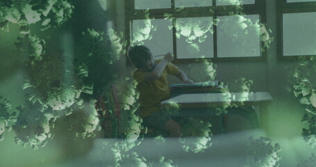 Image of covid 19 cells over schoolboy in face mask at school