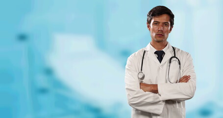 Portrait of caucasian male doctor with arms crossed against hospital in background